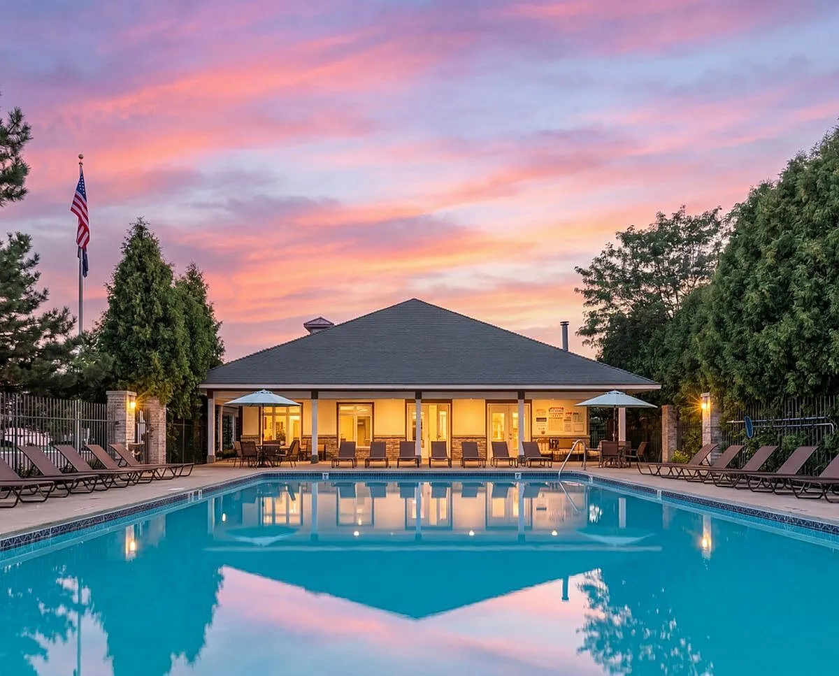Inviting outdoor pool area with elegant lounge chairs and vibrant sunset backdrop, perfect for relaxation and social gatherings Clearview Apartments in Holland, MI
