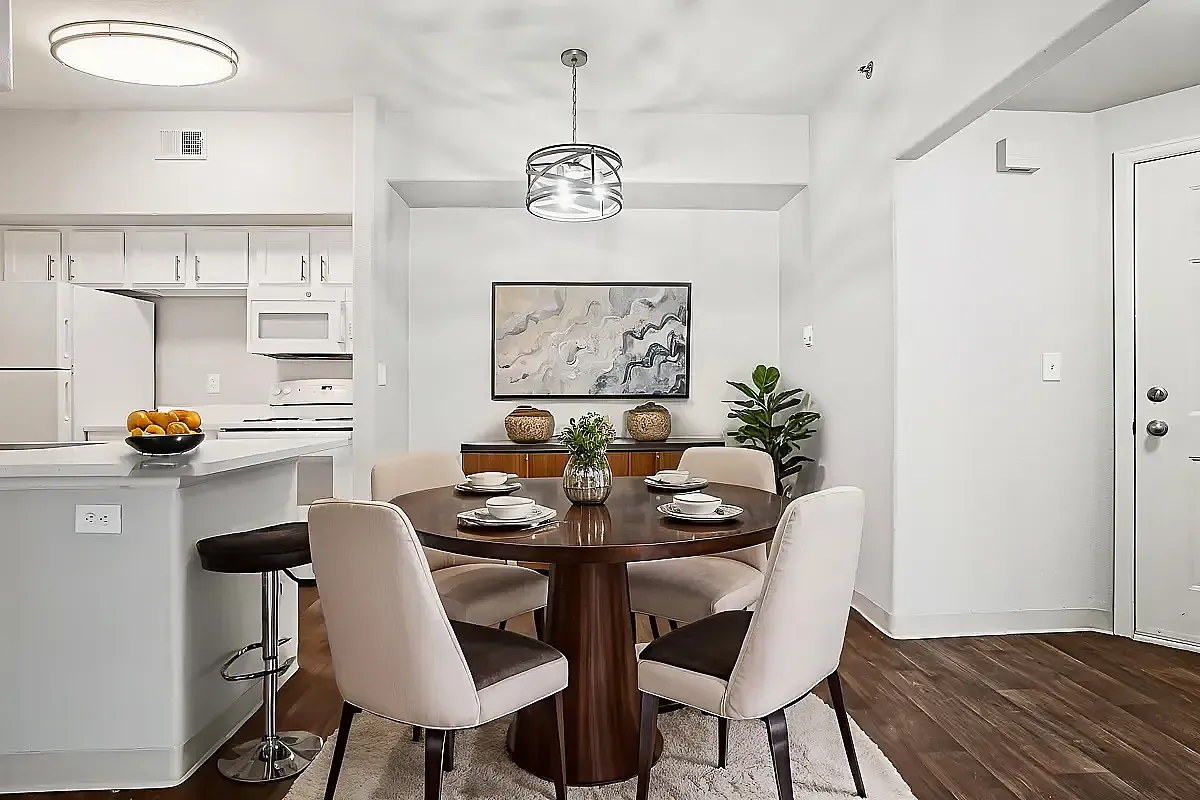 Inviting dining area with elegant round table, modern lighting, and a seamless connection to a contemporary kitchen.