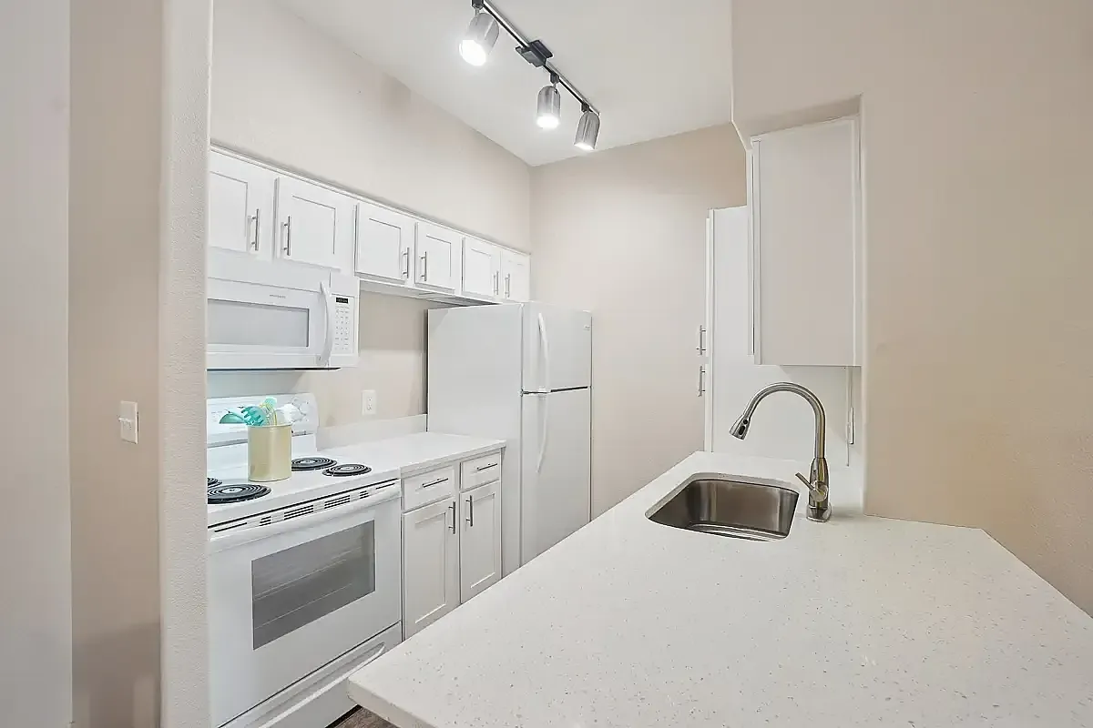 Bright, modern kitchen with sleek white cabinetry, elegant countertops, and stainless steel fixtures.