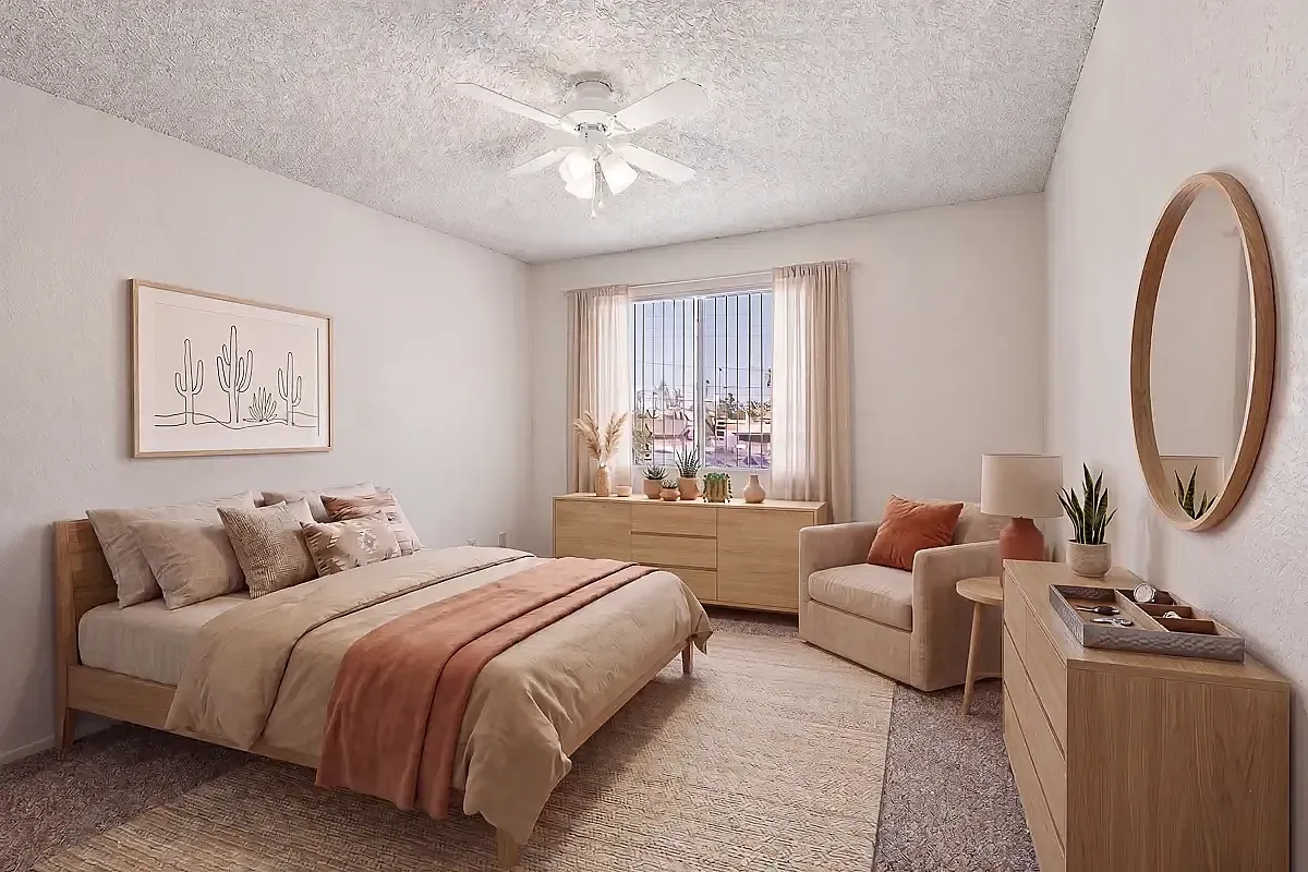 Bright and inviting bedroom with elegant decor, featuring a cozy bed, stylish armchair, and a sunlit window adorned with lush greenery.