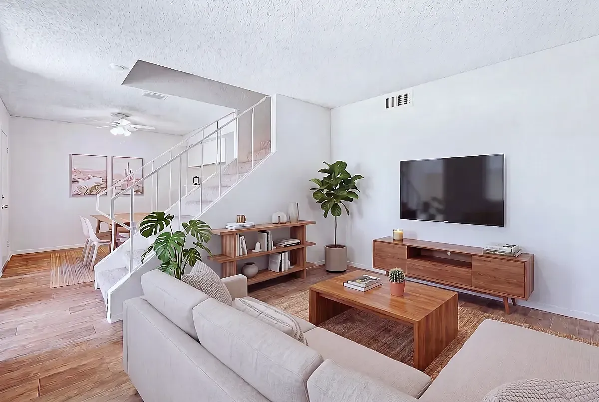 Stylish modern living room with light wood flooring, cozy beige sofas, and elegant wooden furniture, complemented by vibrant green plants and a sleek wall-mounted TV.