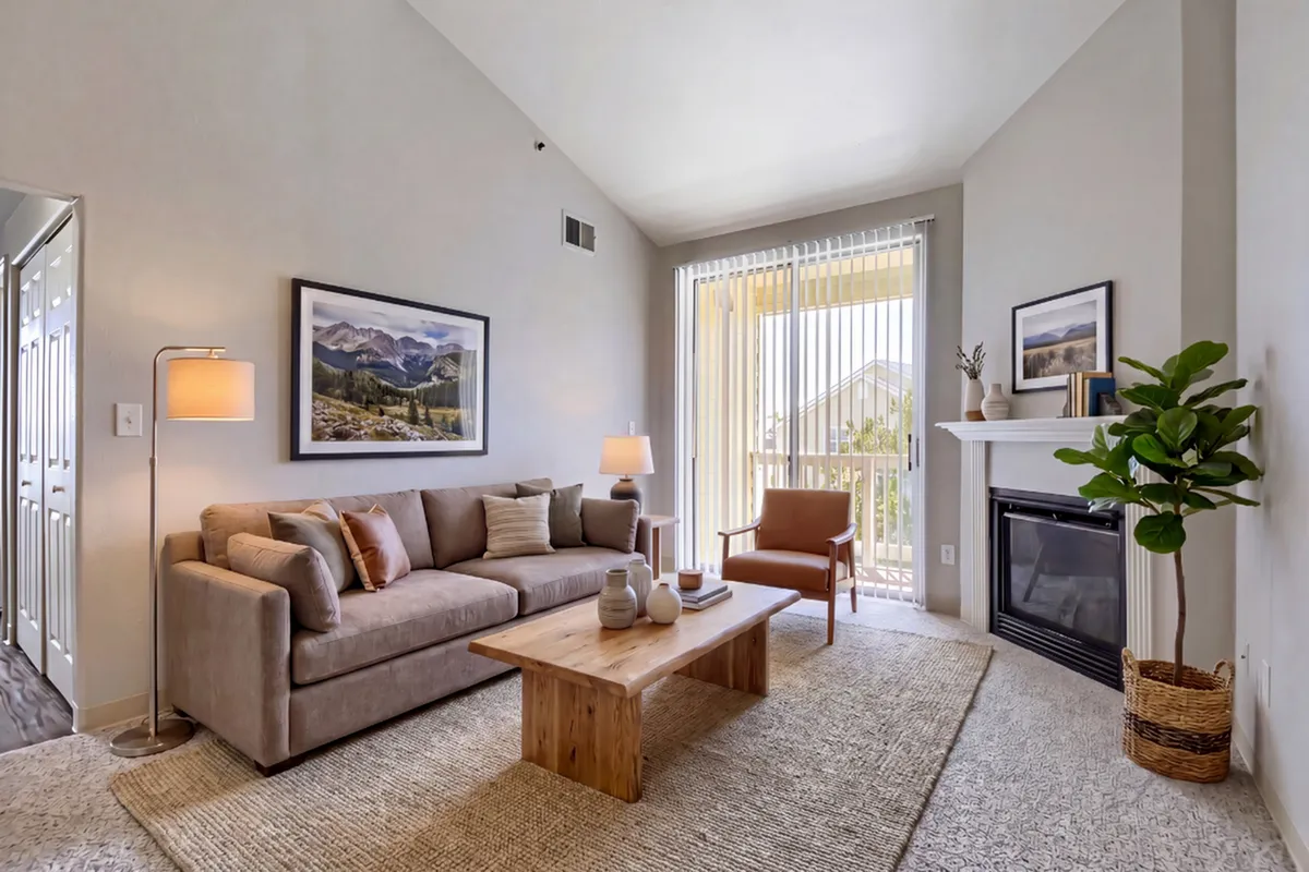 Elegant living room with a cozy sofa, modern decor, and bright natural light streaming through large windows.