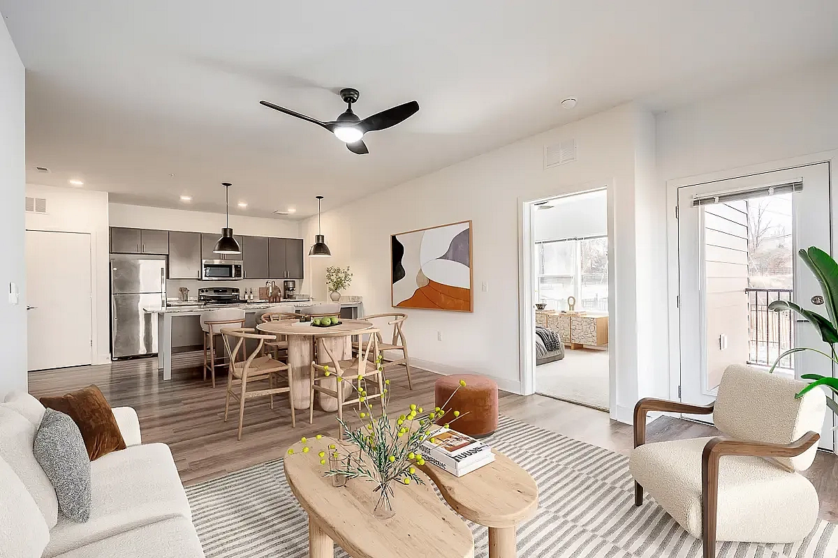 Modern open-concept living area with sleek kitchen, stylish dining space, and cozy seating in a bright and inviting apartment in Charlottesville.