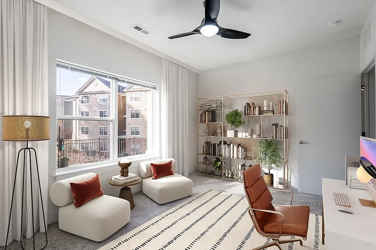 Bright and inviting office space with large window views, cozy seating, and elegant shelving.