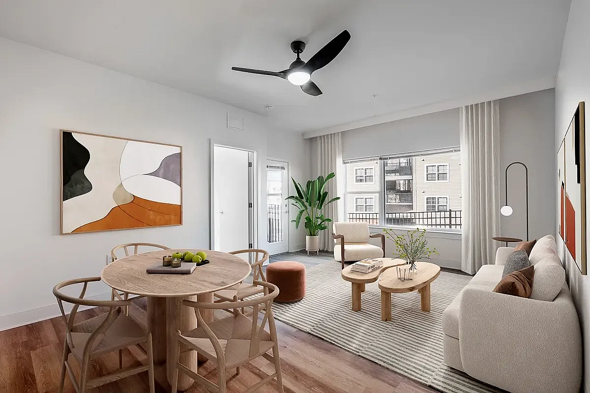 Contemporary living room with stylish decor, featuring a cozy sofa, chic dining area, and expansive windows at 5 Row Apartments in Charlottesville, VA.