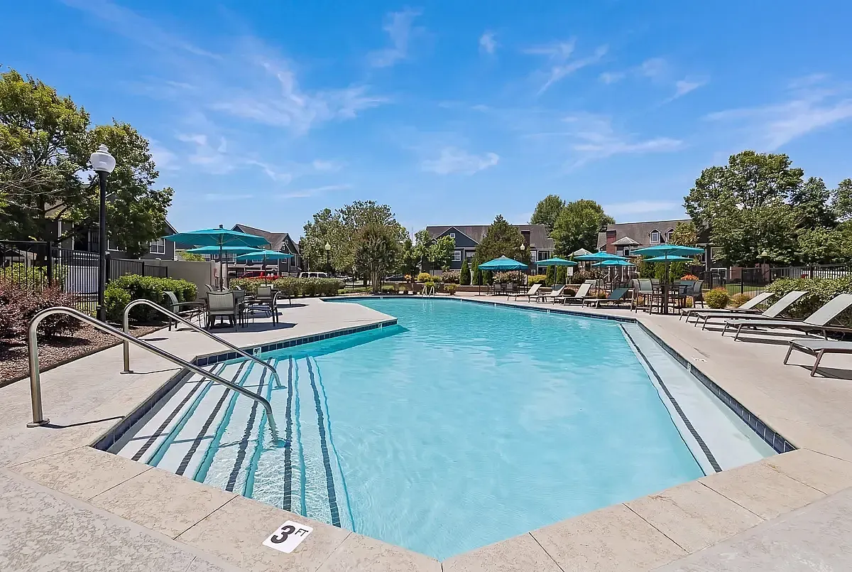 Inviting outdoor pool area with sun loungers, umbrellas, and clear blue water, perfect for relaxation and leisure.