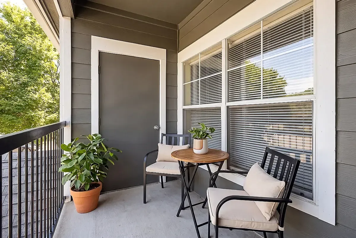 Charming apartment balcony with cozy seating, a potted plant, and relaxing outdoor ambiance at Cason Estates Apartments in Murfreesboro, TN.