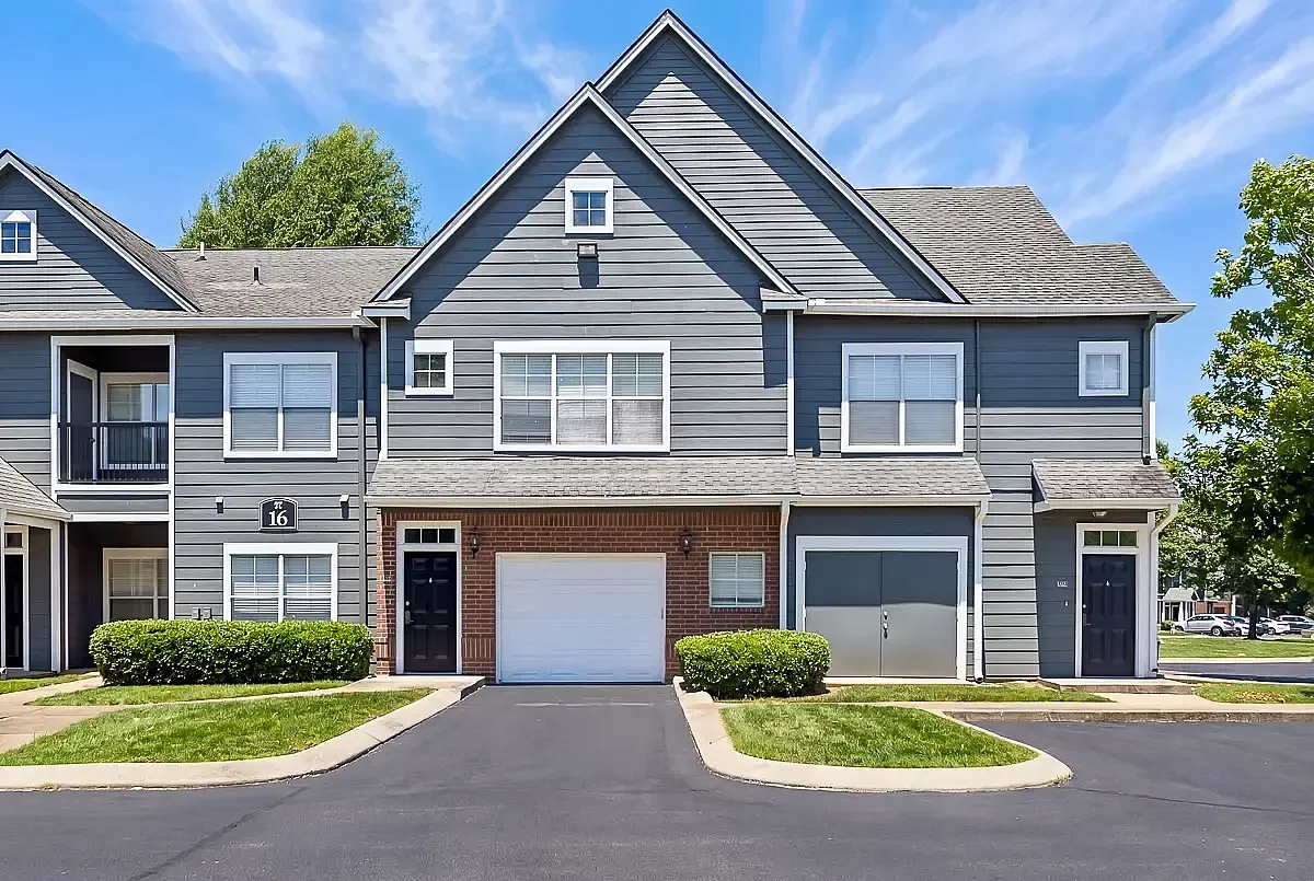 Charming townhouse with modern gray exterior and inviting front porch, nestled in a serene suburban neighborhood.