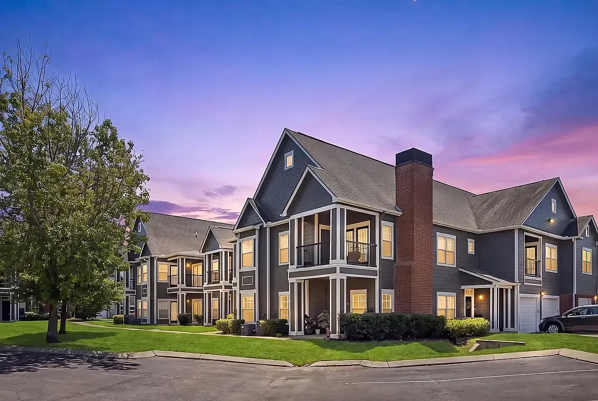 Charming two-story apartment complex with modern facade and inviting balconies, set against a breathtaking twilight sky.