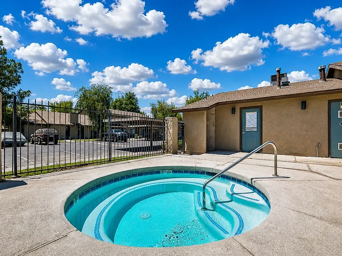 Inviting outdoor hot tub area under a vibrant blue sky, perfect for relaxation and leisure at Camelot Apartments in Yuma, AZ.