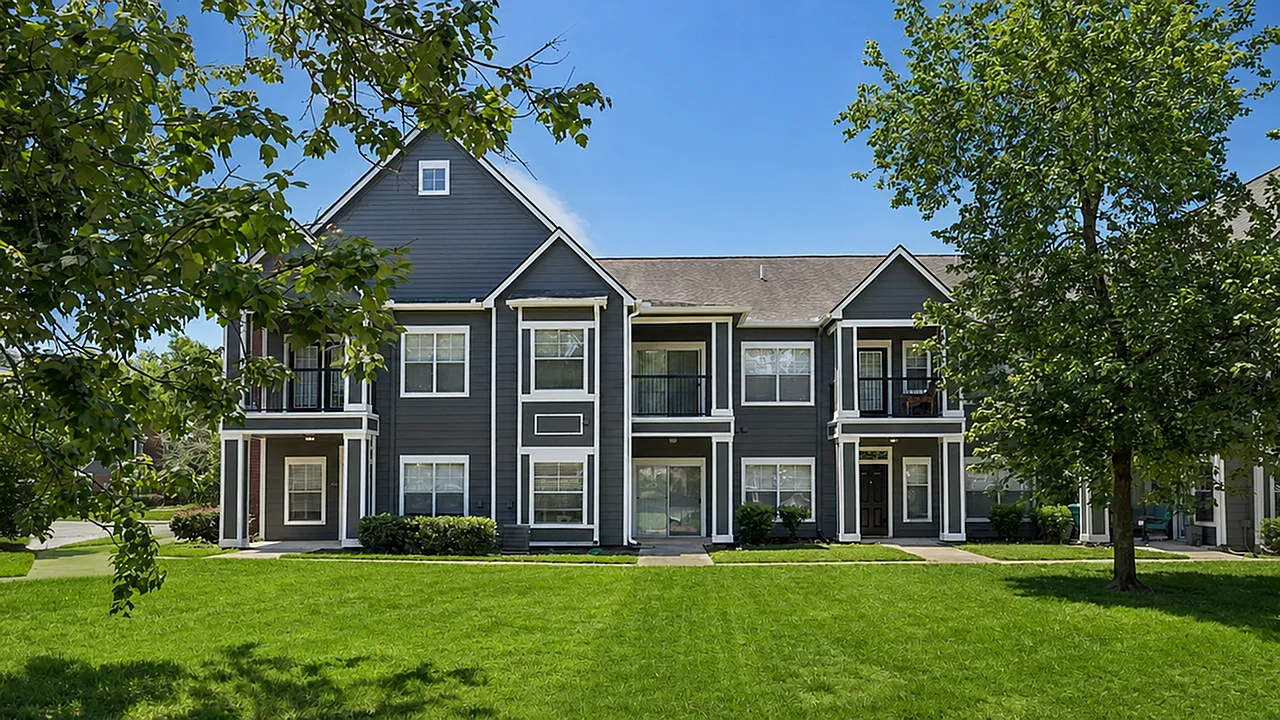 Charming two-story apartment building with modern gray exterior, white accents, and lush greenery in a serene neighborhood setting.