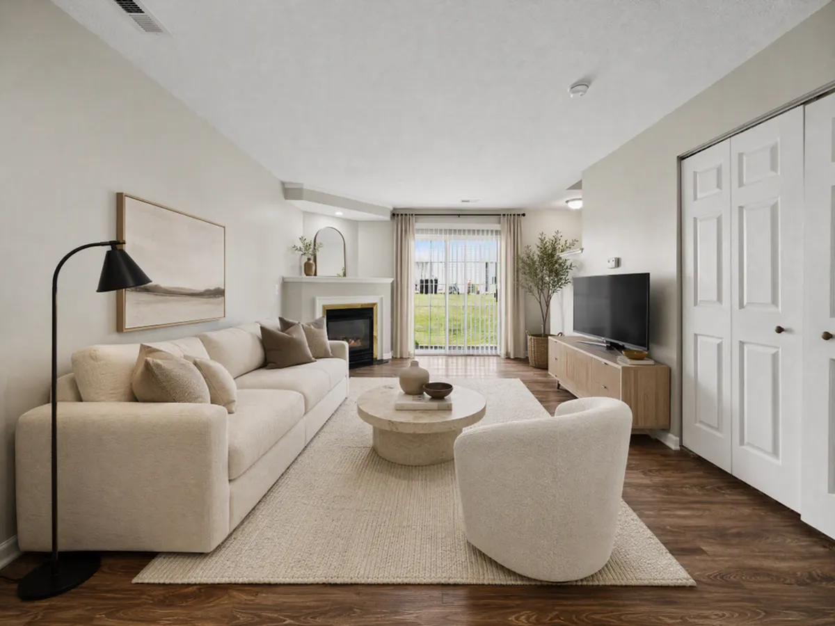 Chic living room boasting a contemporary design with a plush sectional sofa, cozy armchair, and a sleek modern fireplace, perfect for relaxation at Alkire Glen Apartments in Columbus Ohio.