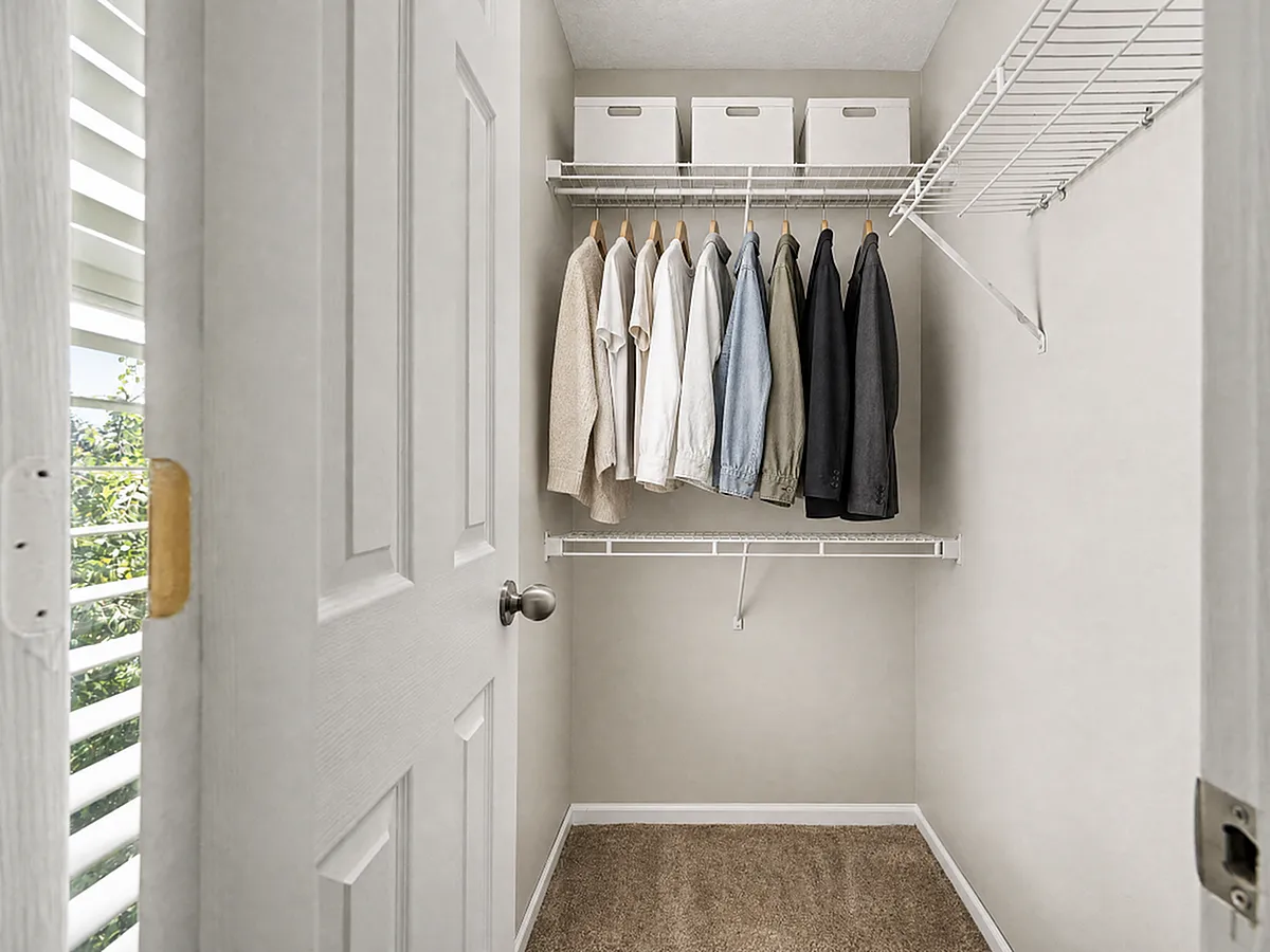 Spacious walk-in closet featuring custom wire shelving and hanging rods at Alkire Glen in Columbus, OH.