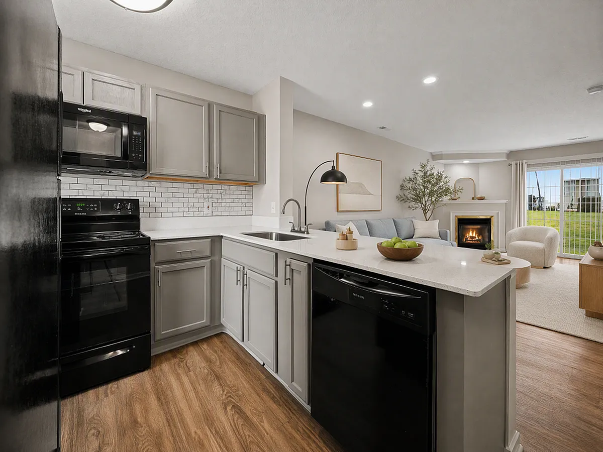 Modern open-concept kitchen and living room with elegant cabinetry, cozy fireplace, and natural light streaming through glass doors.