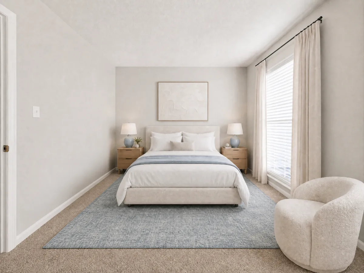 Elegant bedroom with cozy bed, soft lighting, and plush chair, creating a serene retreat.
