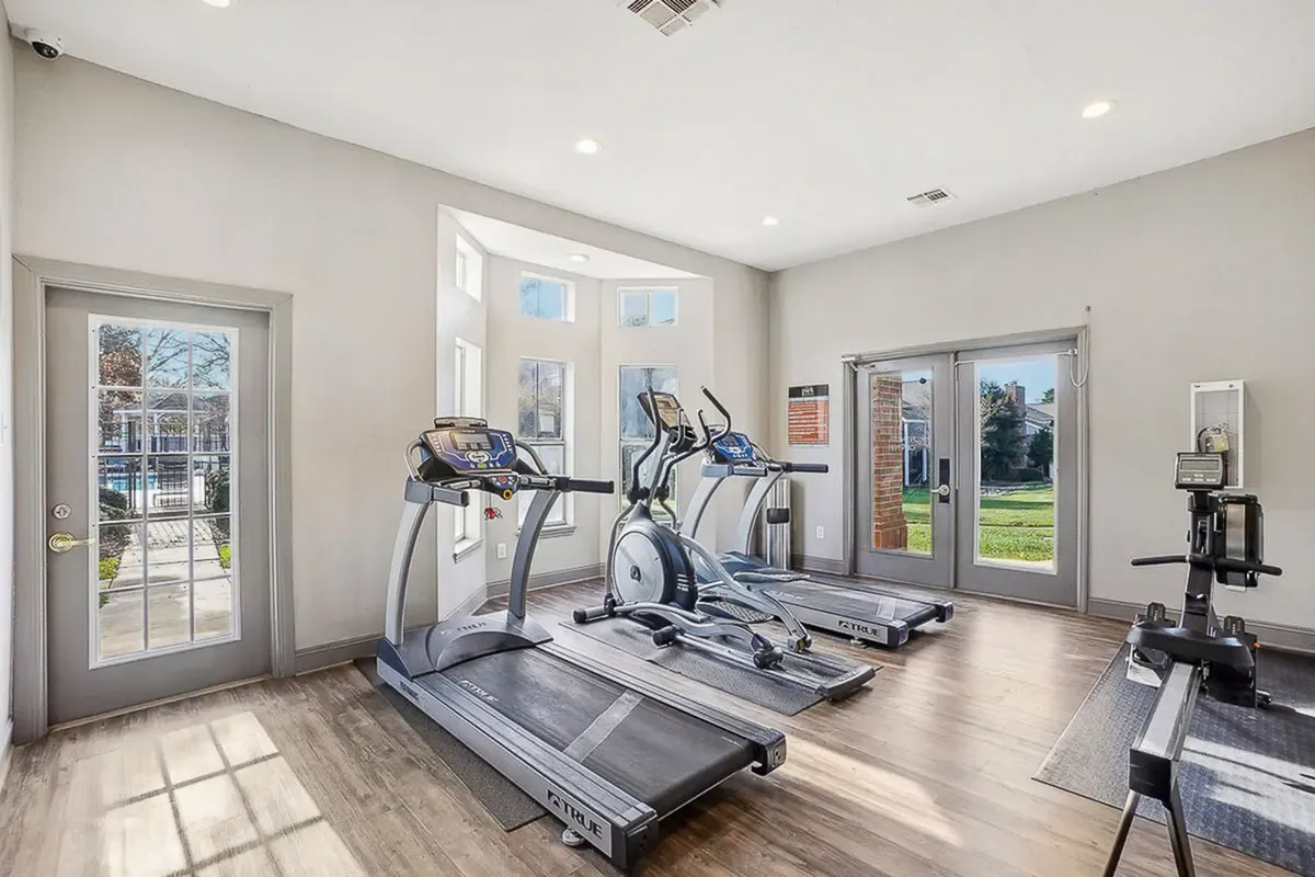Bright and inviting gym at Park at Midtown Apartments with modern equipment, featuring large windows with scenic outdoor views.