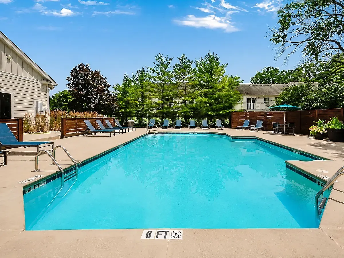 Inviting outdoor pool area with comfortable lounge chairs and lush greenery, perfect for relaxation and leisure.