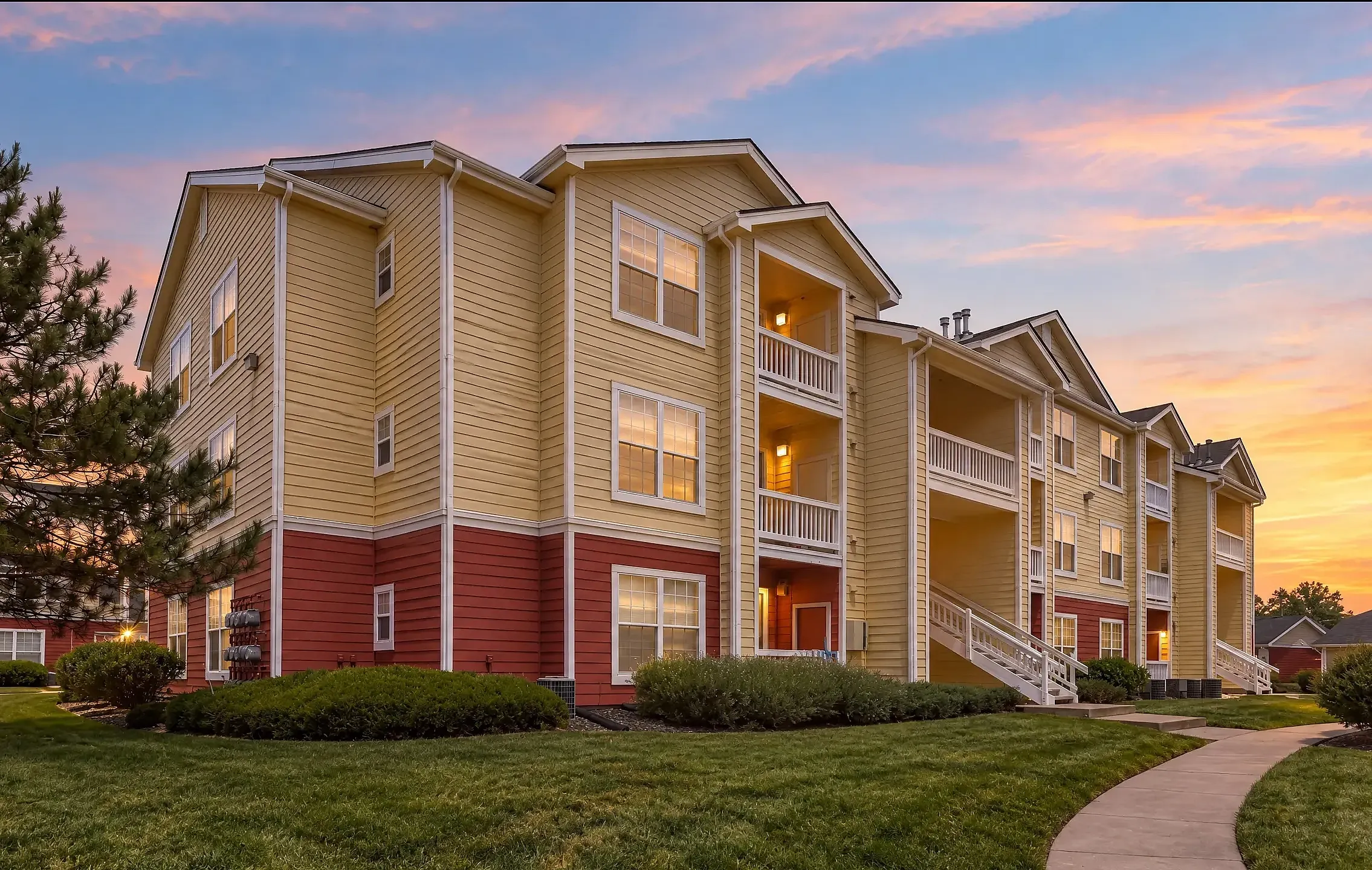 View of Orchards At Cherry Creek Building Exterior at Dusk surrounded by green space and a sidewalk entrance.