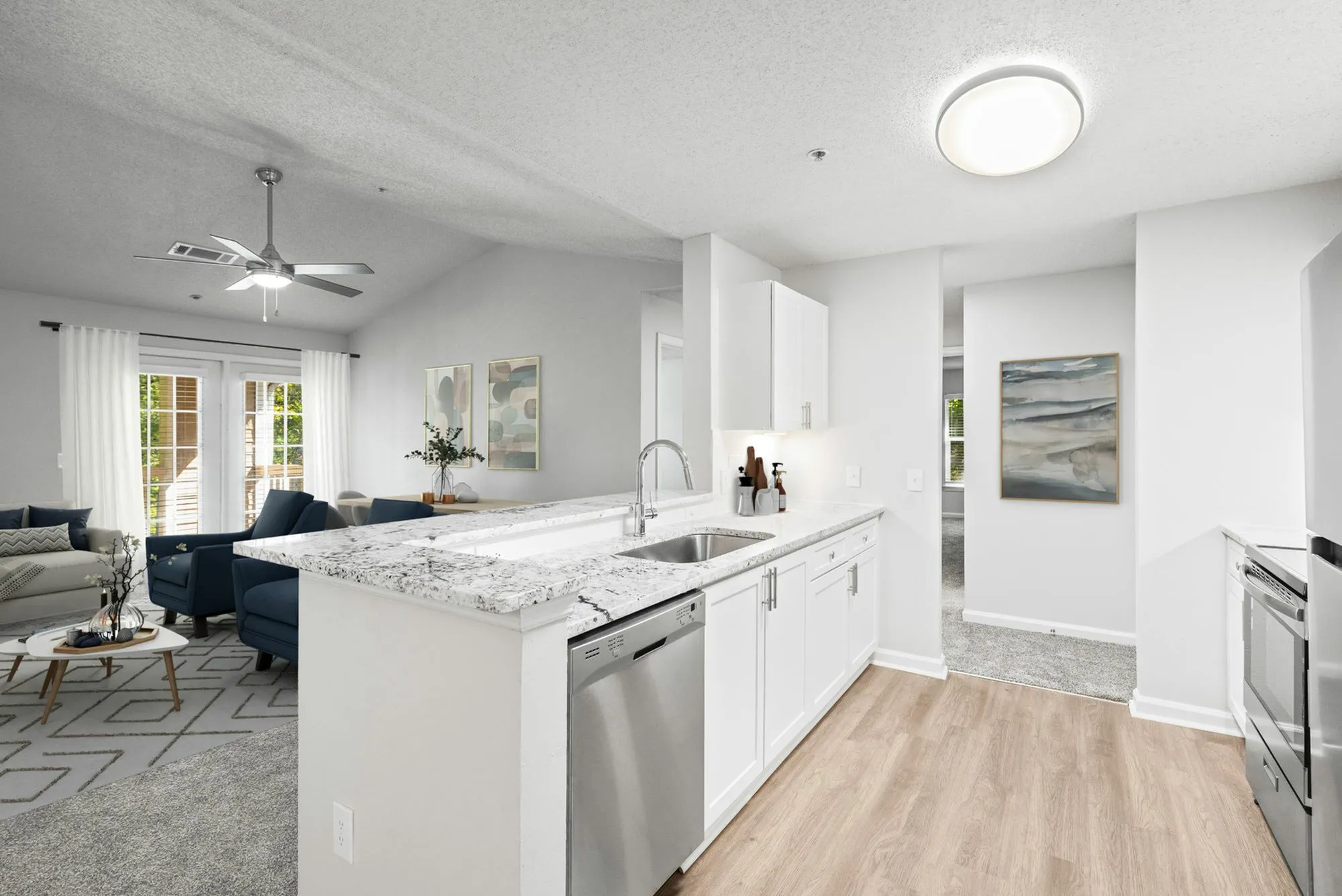Newly renovated open-plan living area with a stylish kitchen and cozy seating, featuring bright natural light and elegant decor Retreat at Peachtree City Apartments