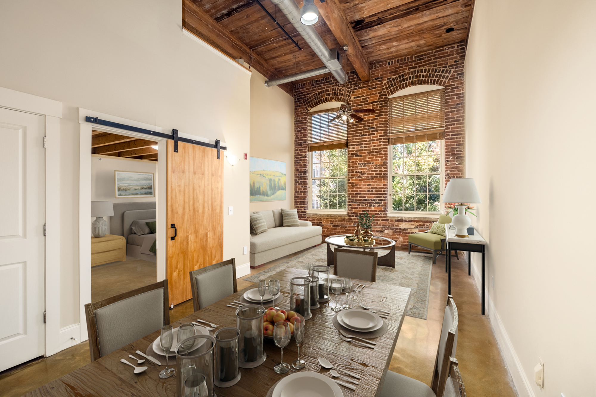 Chic loft apartment featuring exposed brick walls, wooden ceiling beams, and a stylish dining area.