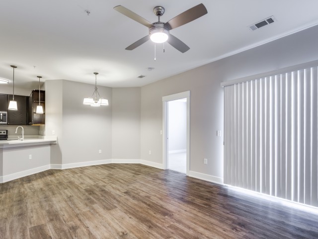 Enjoy Our Vinyl Wood Plank Flooring, With View of Ceiling Fan and Wide Window With Blinds at Cottonwood Reserve Apartments