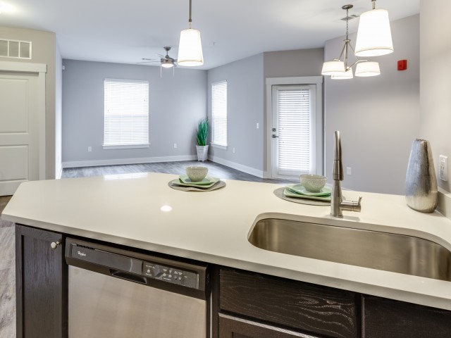 Enjoy Our Granite Look Countertops, With View of White Counters, Deep Sink, and Breakfast Bar at Cottonwood Reserve Apartments