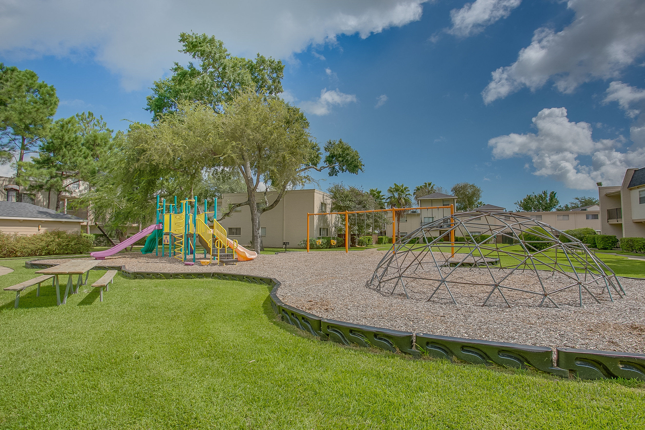 View of Playground, Showing Swing Set, Slides, and Picnic Table at The Regatta Apartments