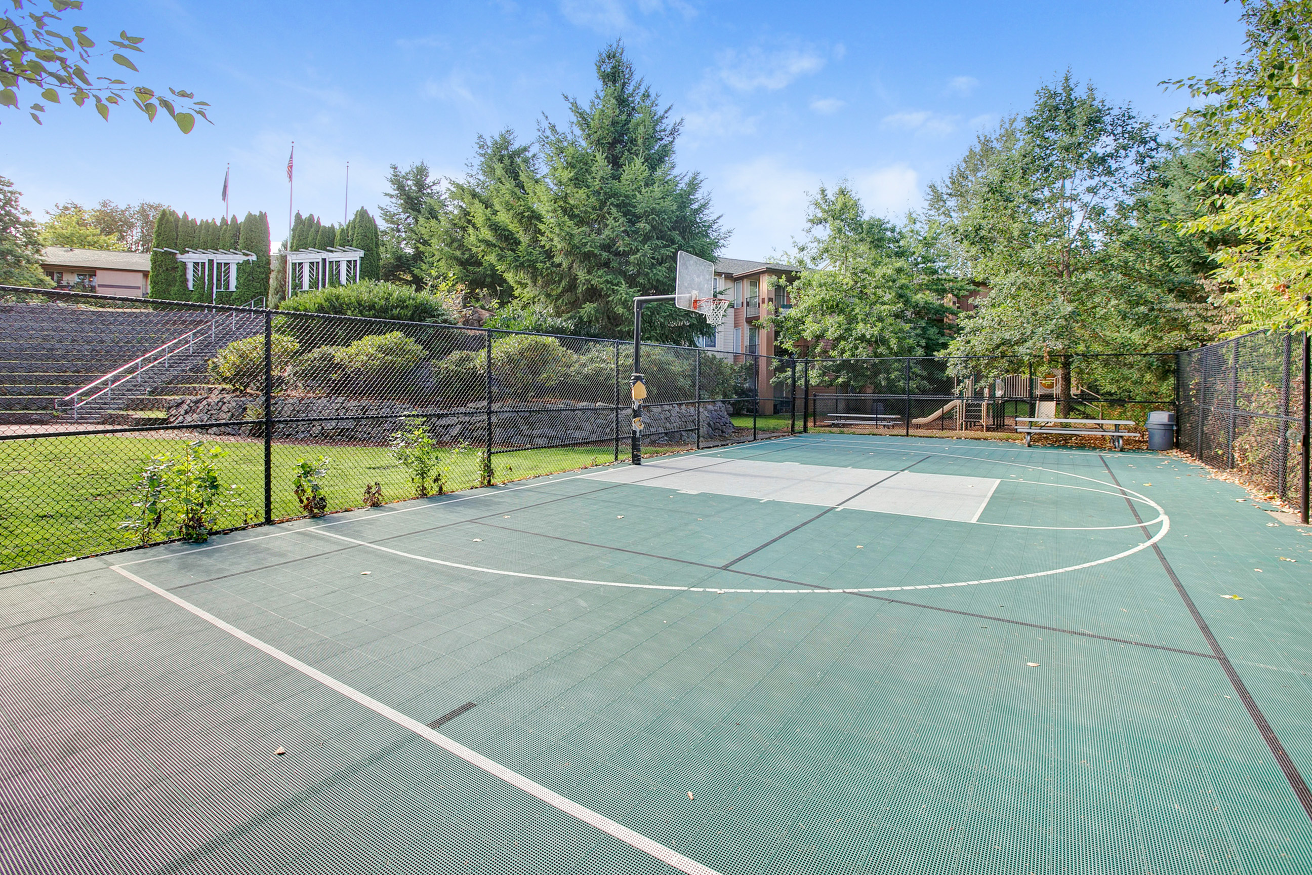 View of Sport Court, Showing Fenced Area and Basketball Net at Scott Mountain Apartments