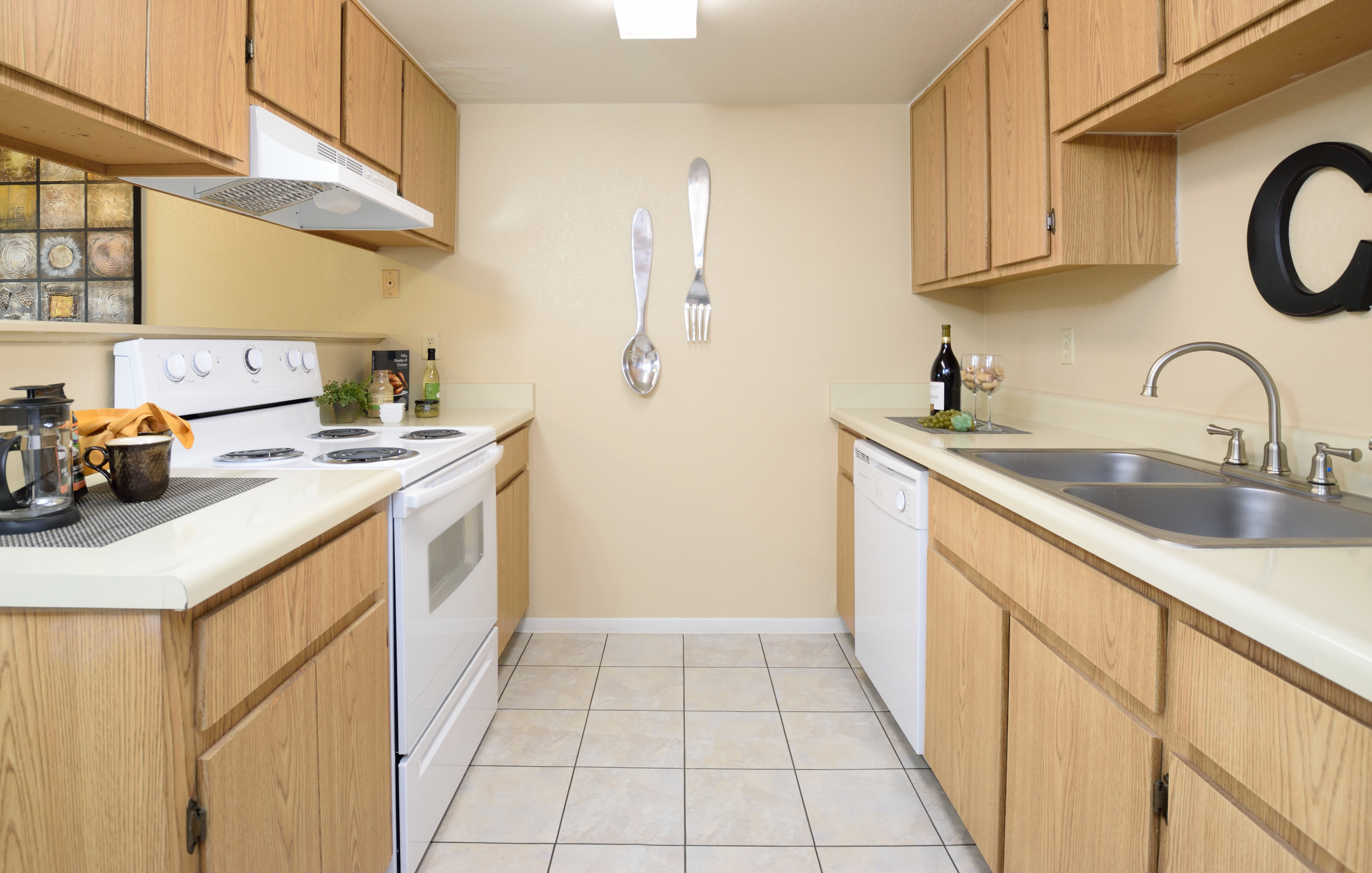View of Kitchen, Showing Galley Style, Gas Appliances, Tile Flooring, Cabinets, Double Sink and Counter Tops,  at Camelot Apartments