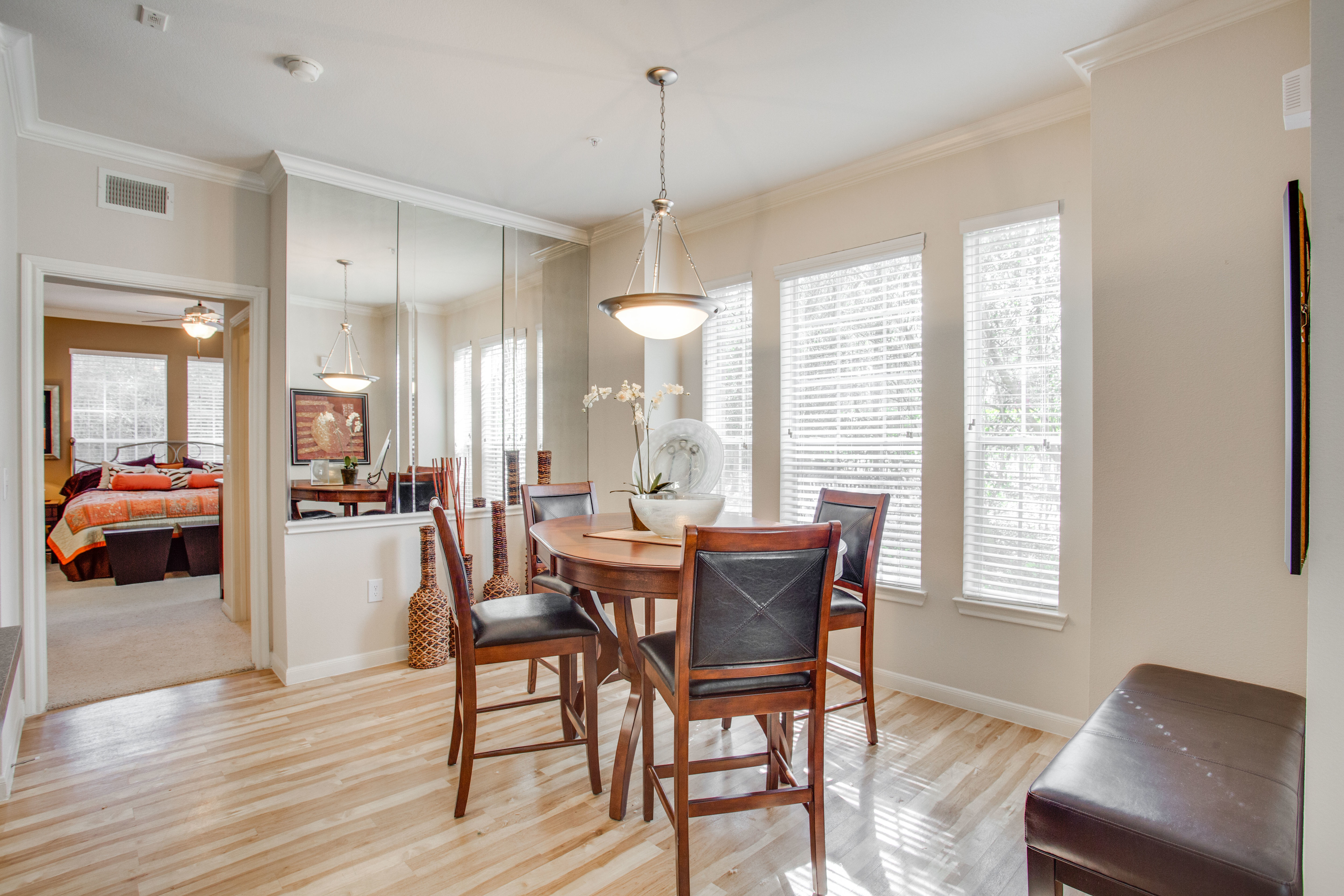 View of Dining Area with Hanging Light, Plank-Wood Flooring, and Décor at Raveneaux Apartments