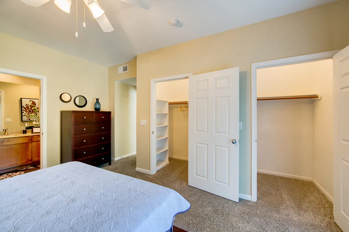 View of Furnished Bedroom, Showing Carpet, Walk-In Closet, and Attached Bathroom at Enclave on Golden Triangle Apartments