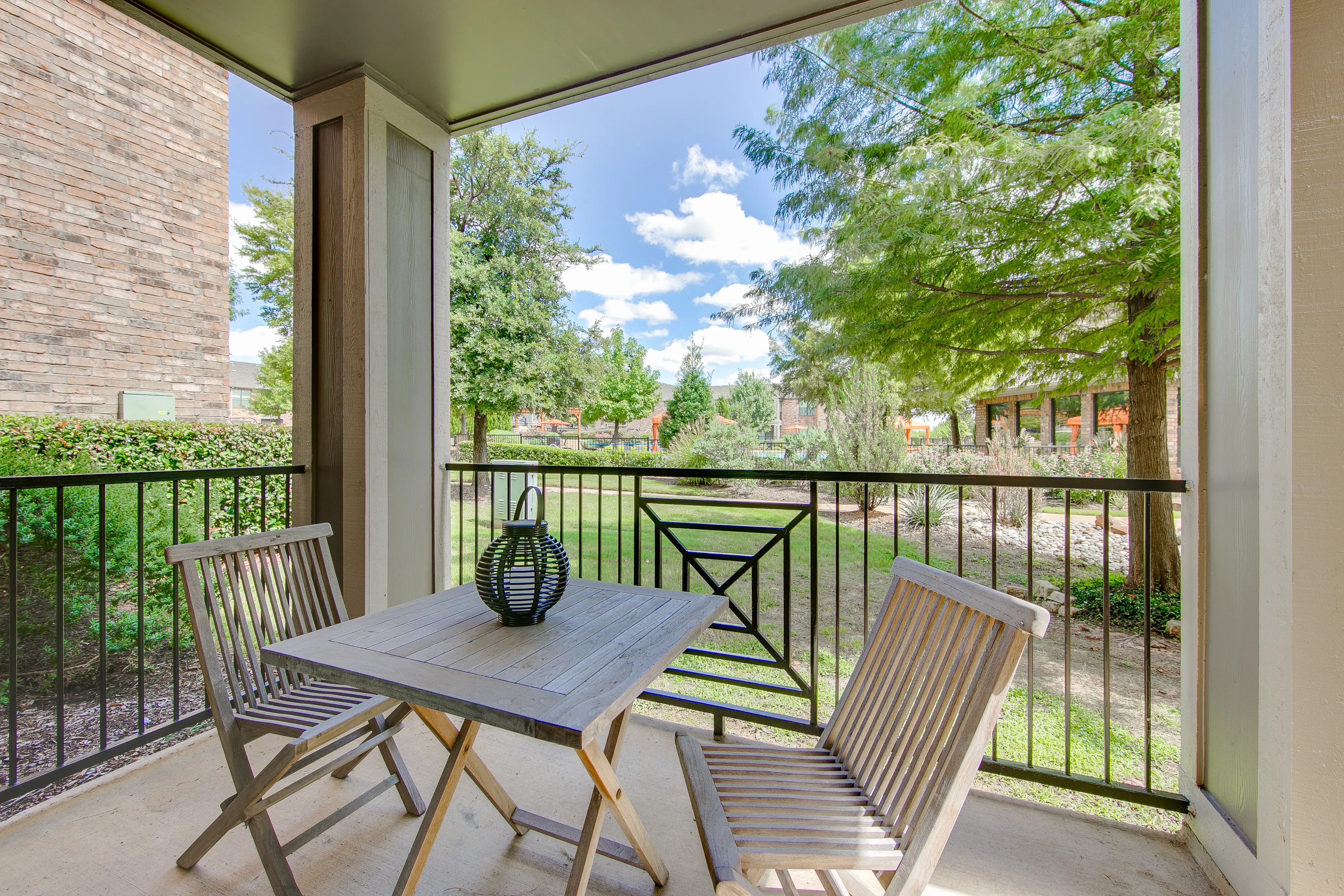 View of Private Patio, Showing Table and Chairs, Landscaping, and Community View at Enclave on Golden Triangle Apartments