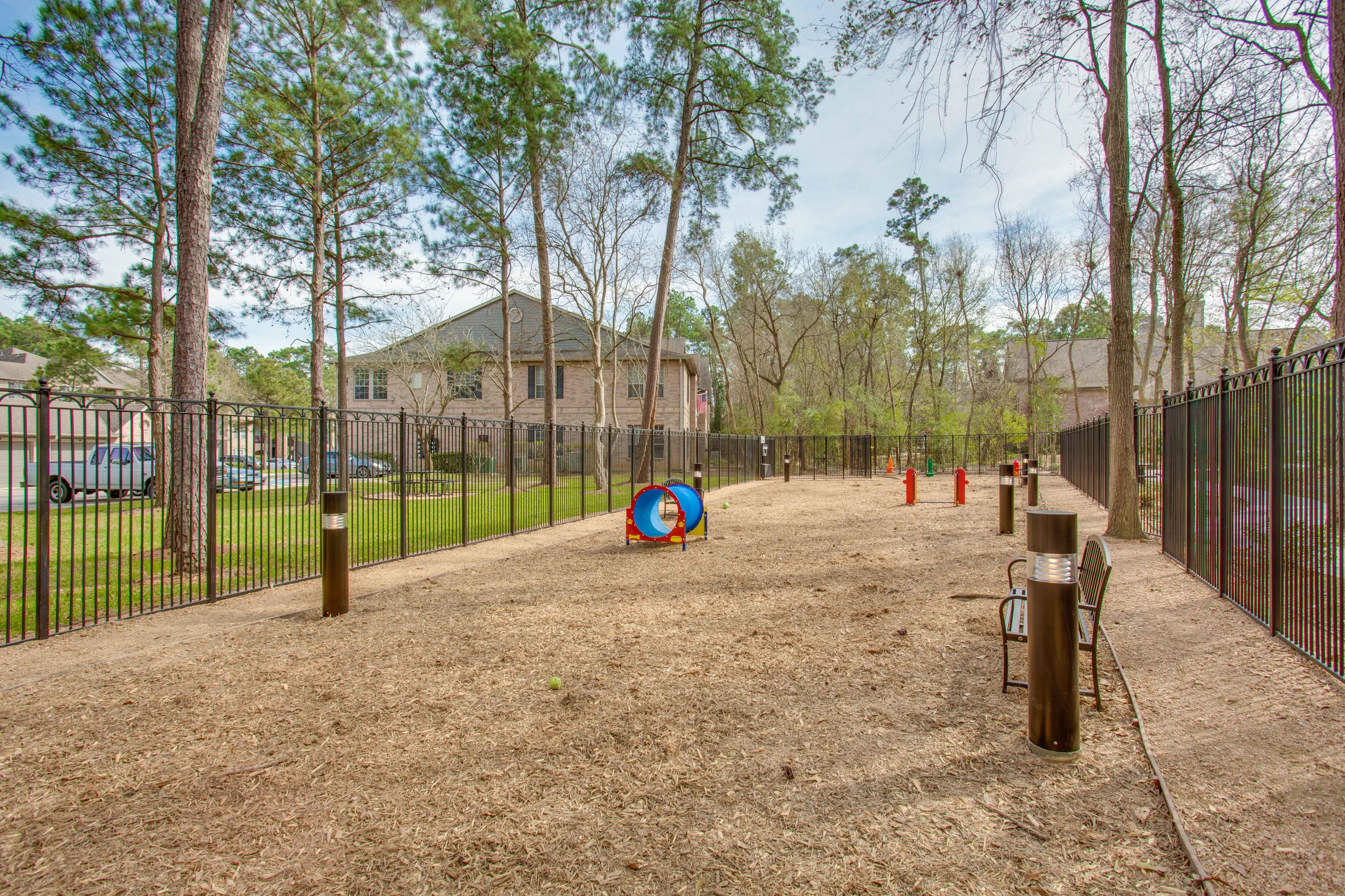 View of Fenced-In Dog Park with Agility Course and Landscaping at Raveneaux Apartments