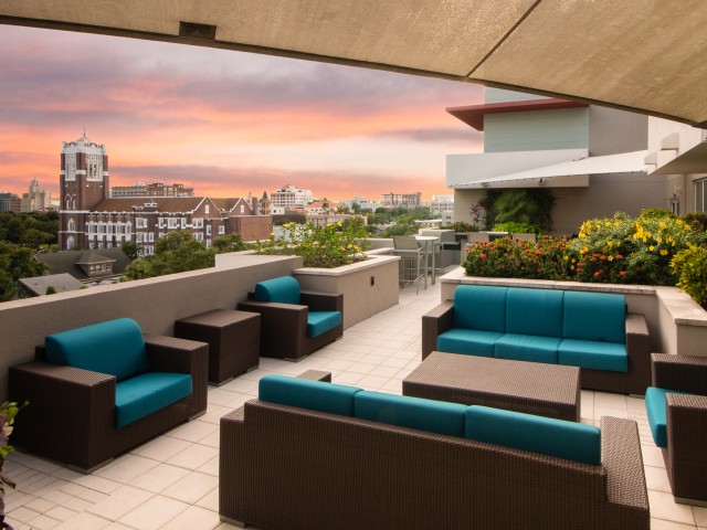 View of Rooftop Lounge, Showing Outdoor Furniture, Grilling Lounge, and View of Downtown St. Pete at Cottonwood Bayview Apartments