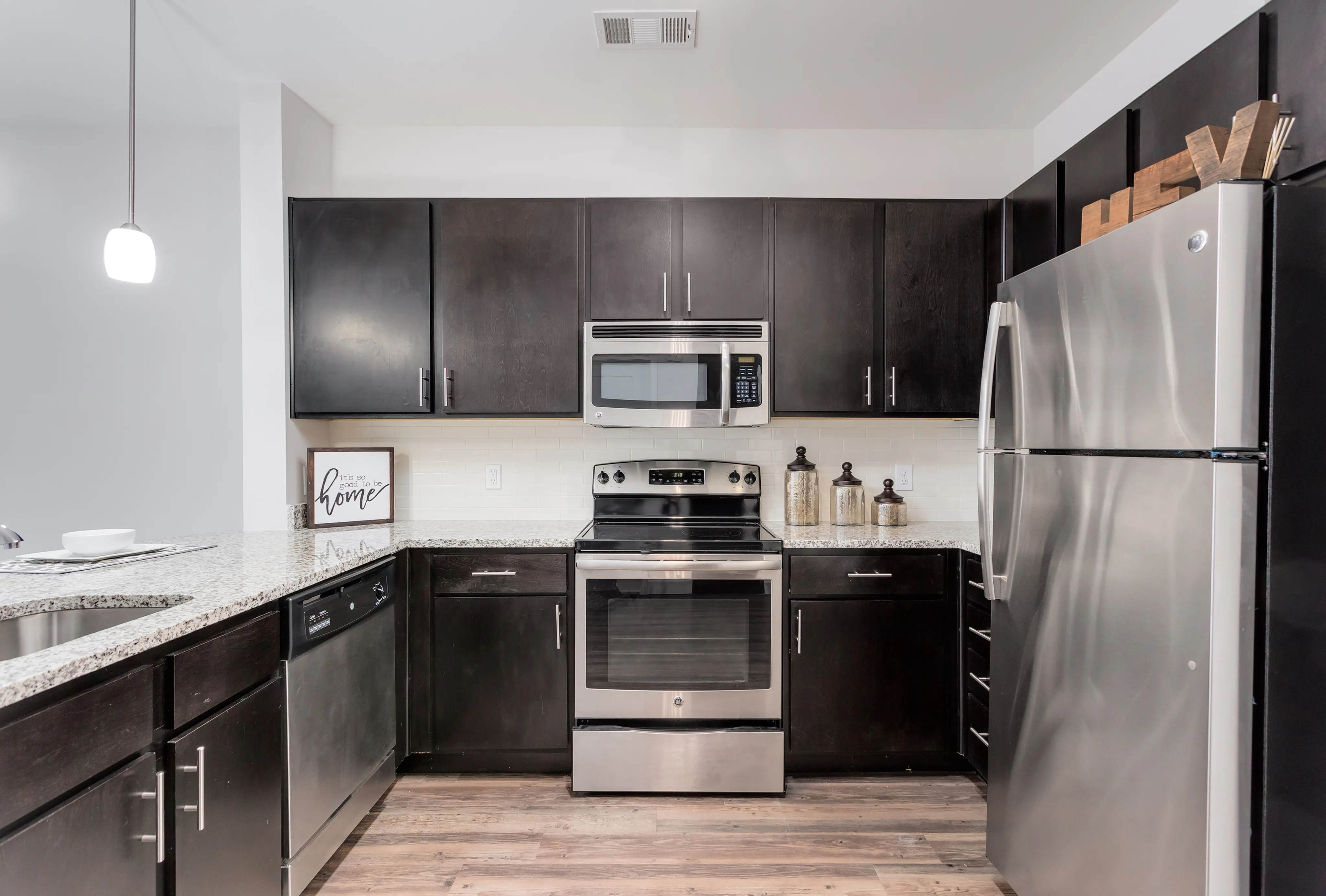 Stylish modern kitchen with dark wood cabinets, stainless steel appliances, and granite countertops.