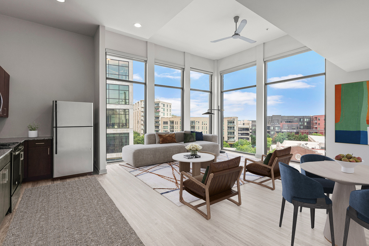 Bright apartment living room with floor-to-ceiling windows showcasing city views, modern furnishings, and open layout design.