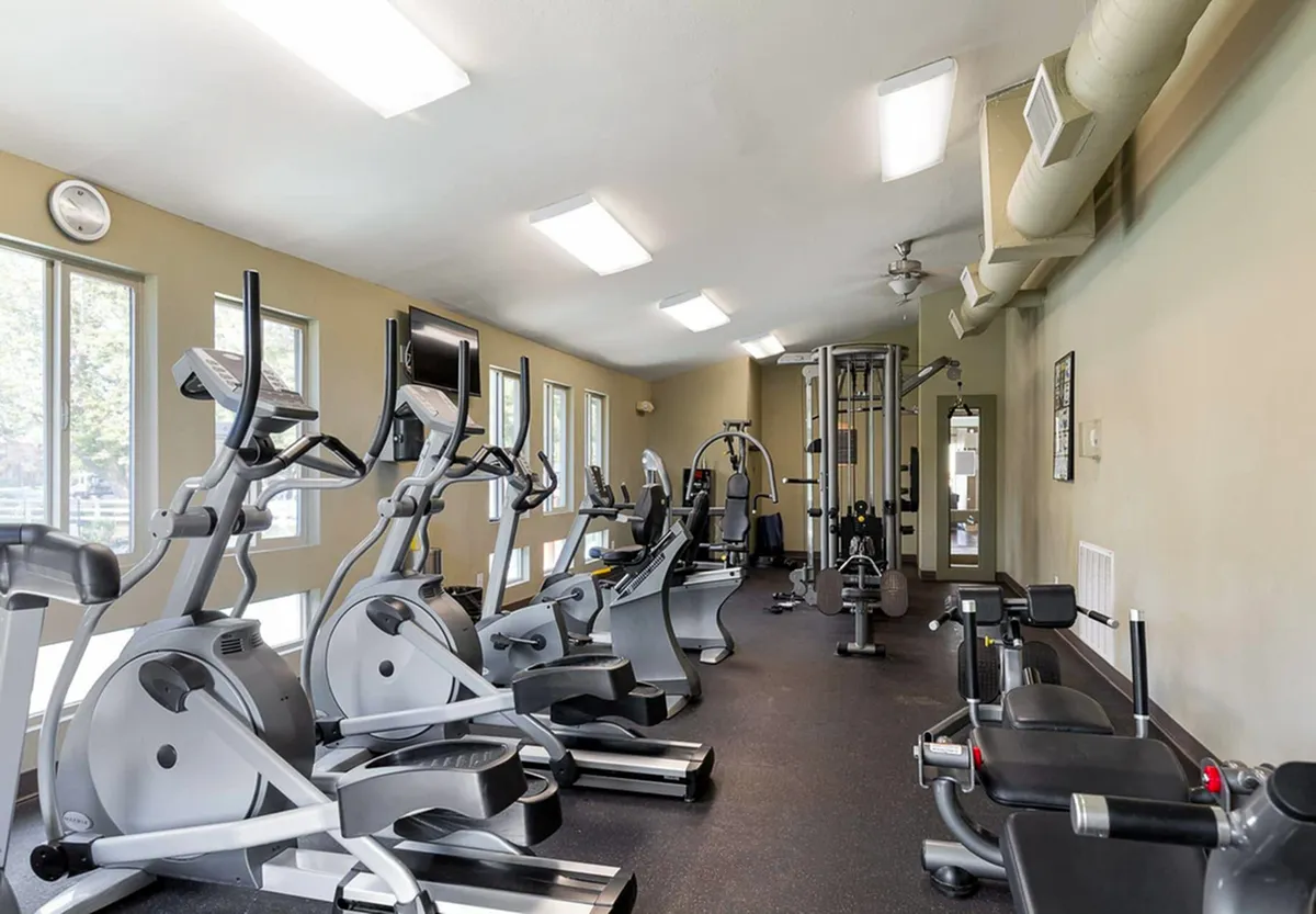 Modern fitness center at Fox Point in Old Farm Apartments with state-of-the-art exercise equipment, bright natural lighting, and sleek design.