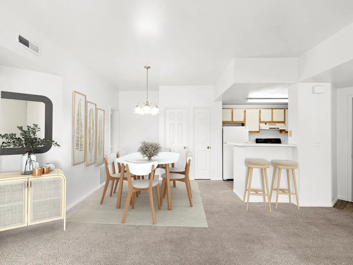 Elegant open-concept dining and kitchen area at Fox Point in Old Farm Apartments with modern decor, featuring a stylish dining set, neutral tones, and inviting bar stools.