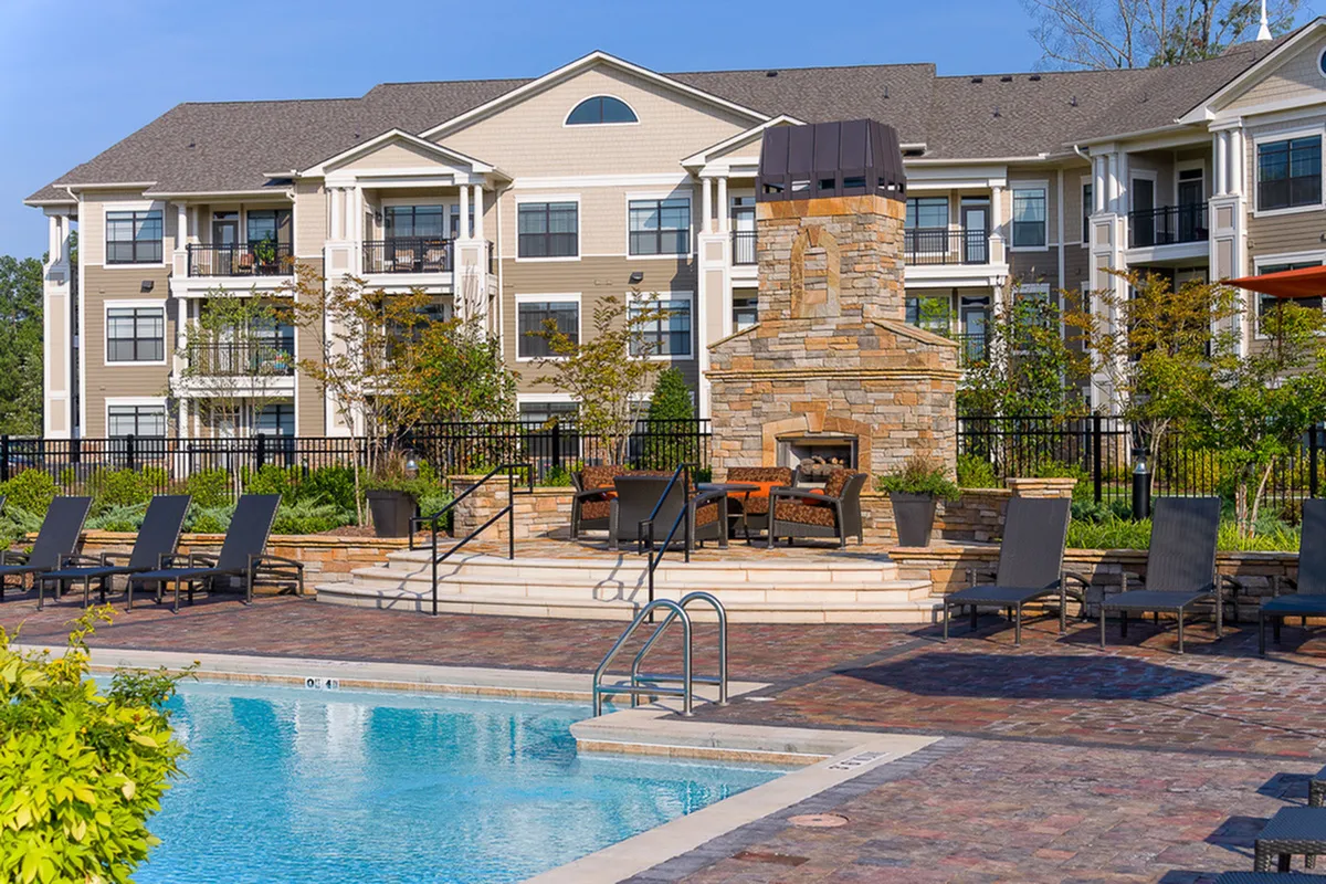Luxurious apartment complex, Heights at Meridian, featuring a beautiful outdoor pool, elegant stone fireplace, and cozy lounge area, perfect for relaxation and socializing.