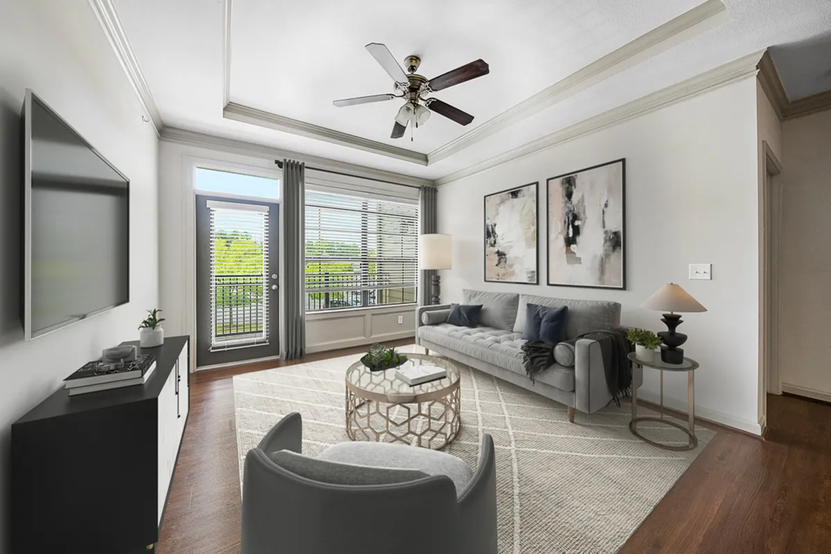 Elegant living room at Heights at Meridian Apartments with a modern ceiling fan, stylish artwork, and large windows providing abundant natural light.
