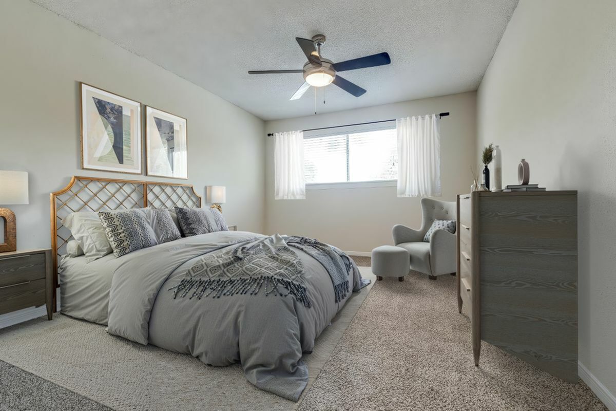 Elegant bedroom with a plush bed, chic decor, and abundant natural light filtering through large windows.