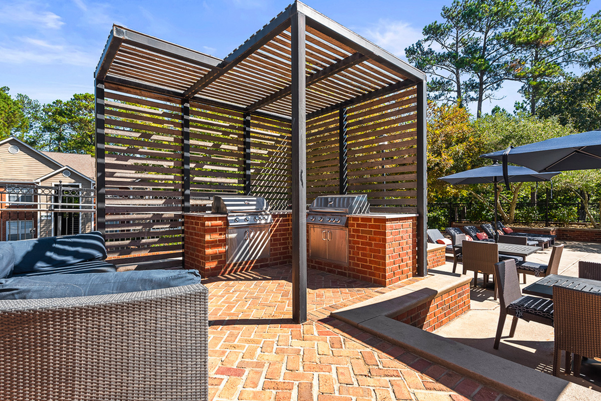 Inviting outdoor lounge with modern pergola and built-in grills, perfect for alfresco dining and relaxation.