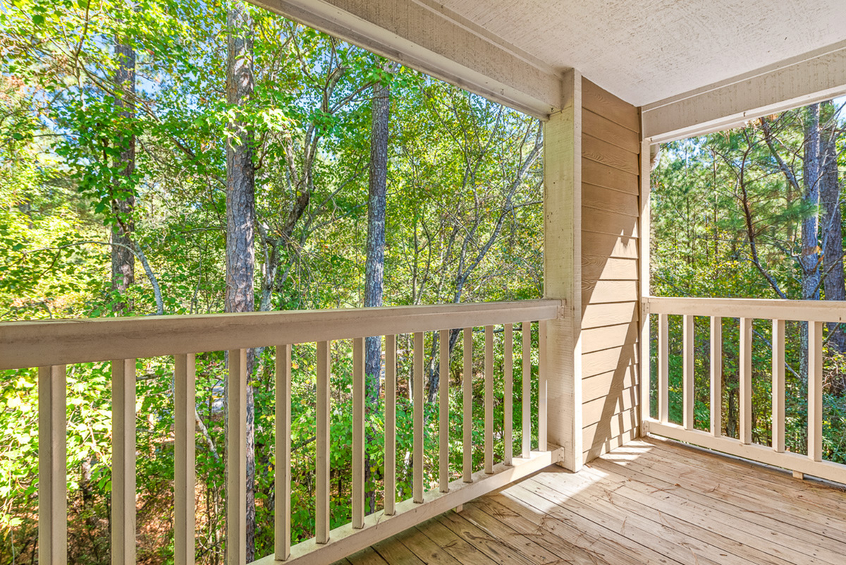 Charming apartment balcony with serene forest views, perfect for relaxation and enjoying nature.