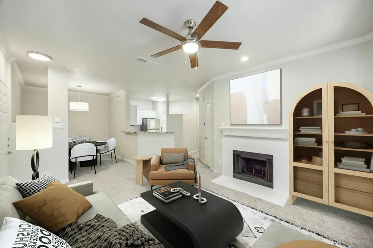 Inviting open-concept living area featuring a cozy fireplace, modern ceiling fan, and elegant dining space.
