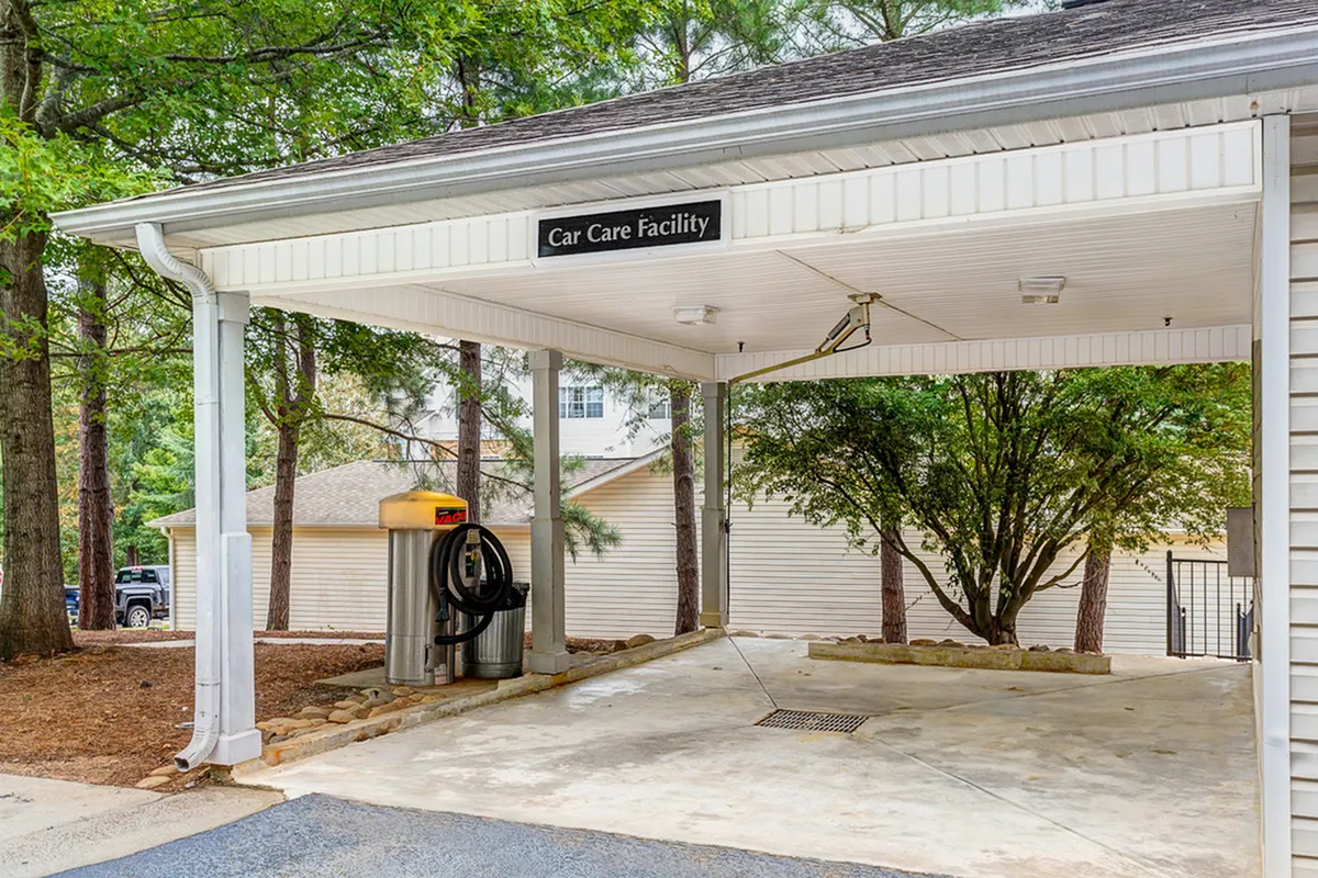 Convenient car care facility set amidst lush greenery, offering a practical space for vehicle maintenance.