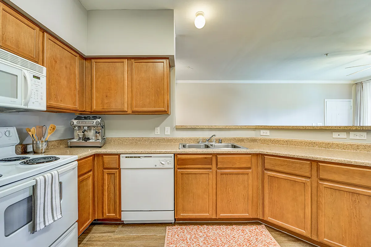 Charming kitchen with warm wood cabinets, modern appliances, and a spacious countertop, perfect for gourmet cooking.