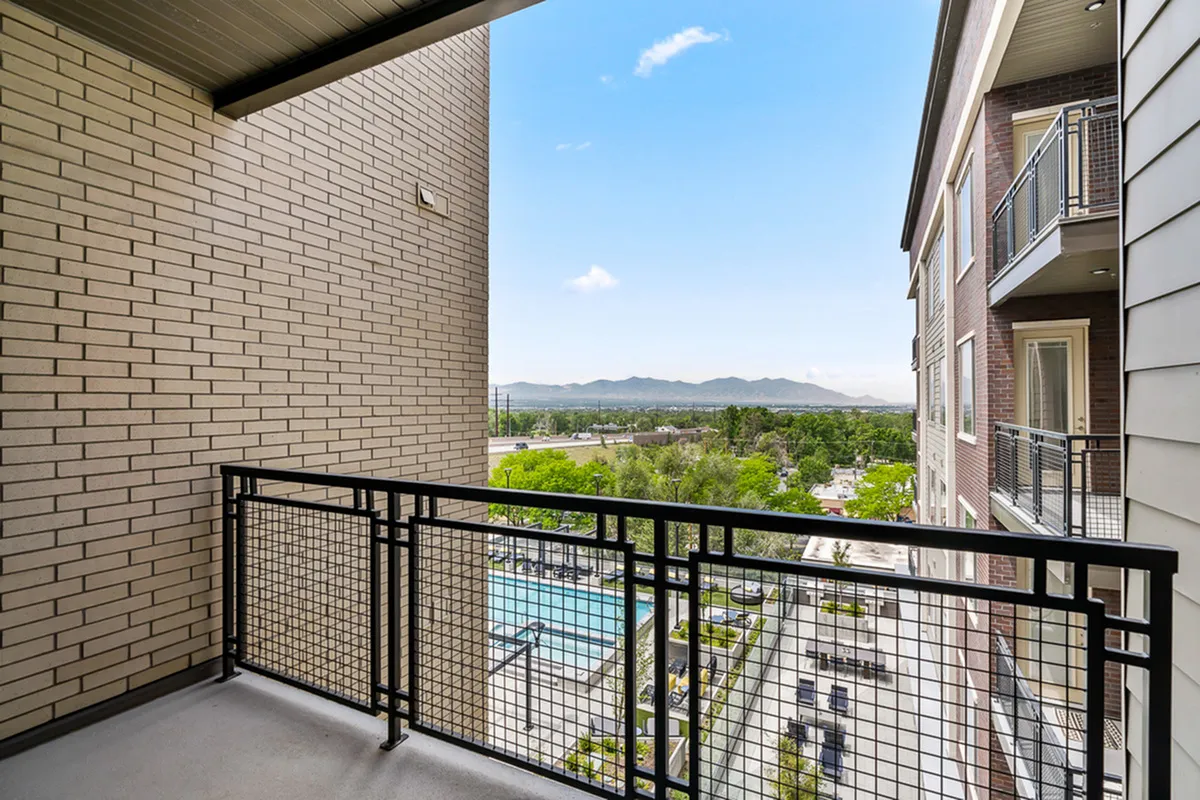 Inviting apartment balcony with picturesque mountain and city views, offering a perfect mix of urban and natural beauty.