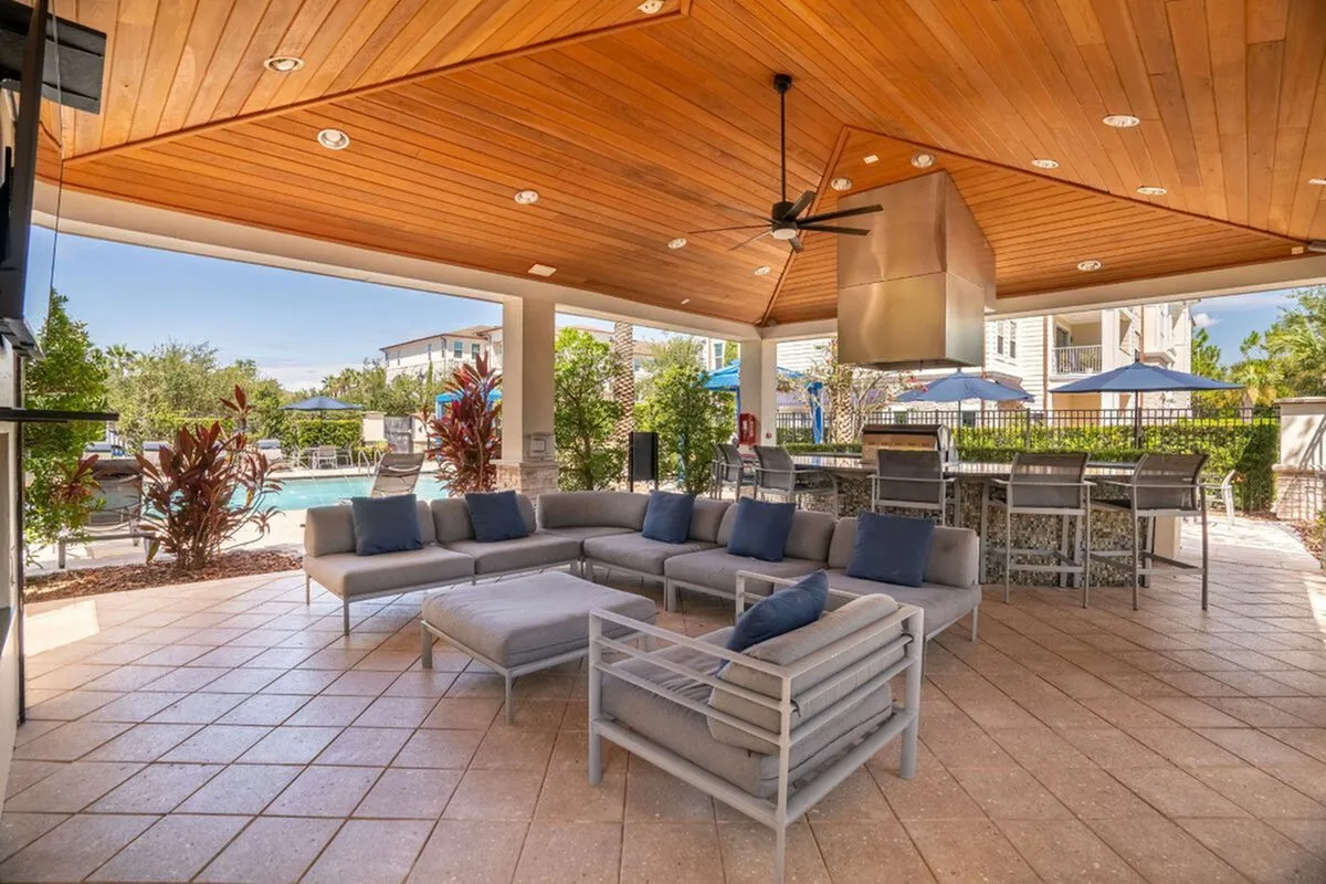 Luxurious outdoor patio with modern seating, sleek bar area, and inviting pool view, perfect for entertaining at The Marq Highland Park Apartments in Westchase Tampa