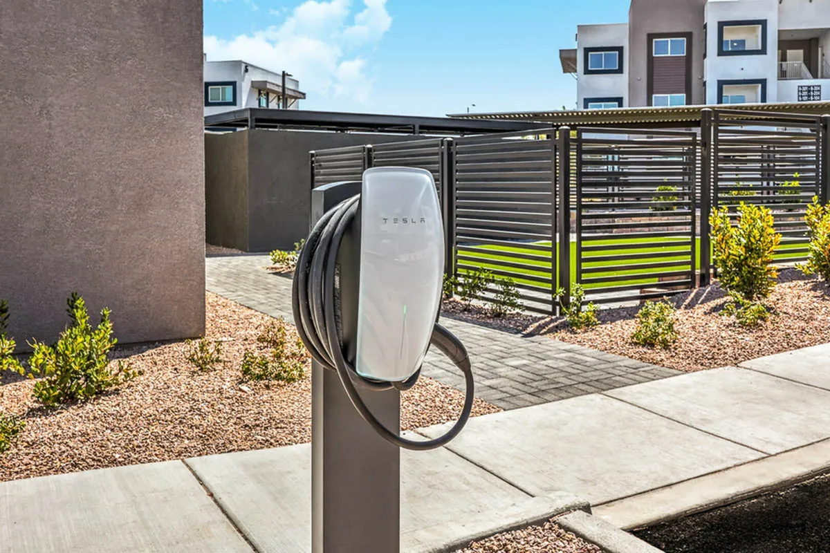Modern apartment complex with convenient Tesla charging station, offering eco-friendly living in a stylish urban setting.