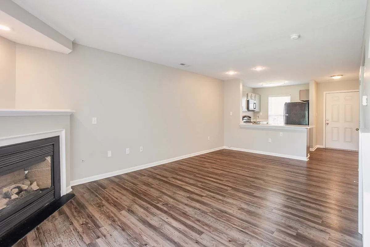 Elegant open-concept living space with modern kitchen, cozy fireplace, and stylish wood flooring.